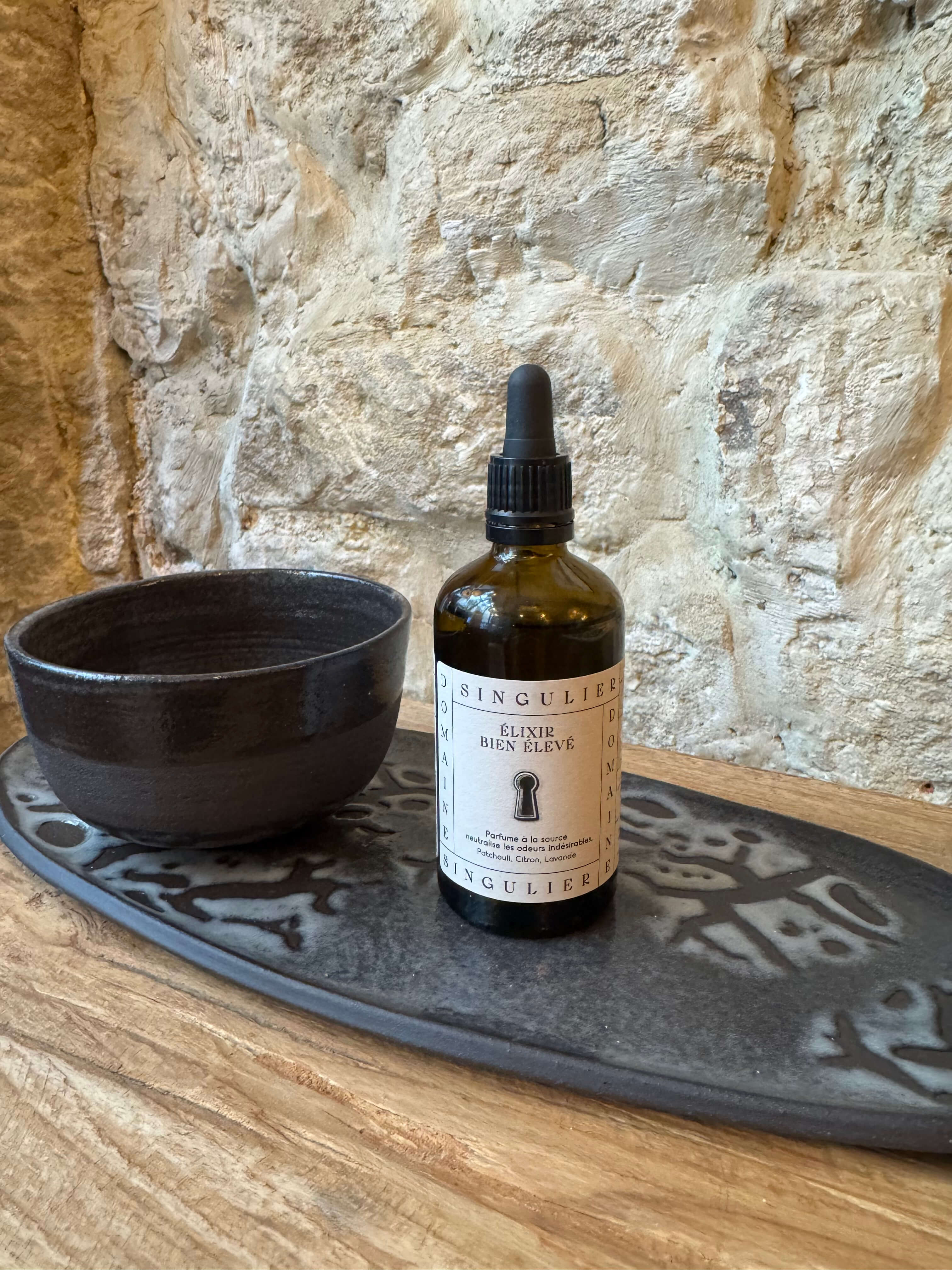 Elixir Bien Élevé Domaine Singulier disposé sur une création en céramique de Gabrielle Lenoir