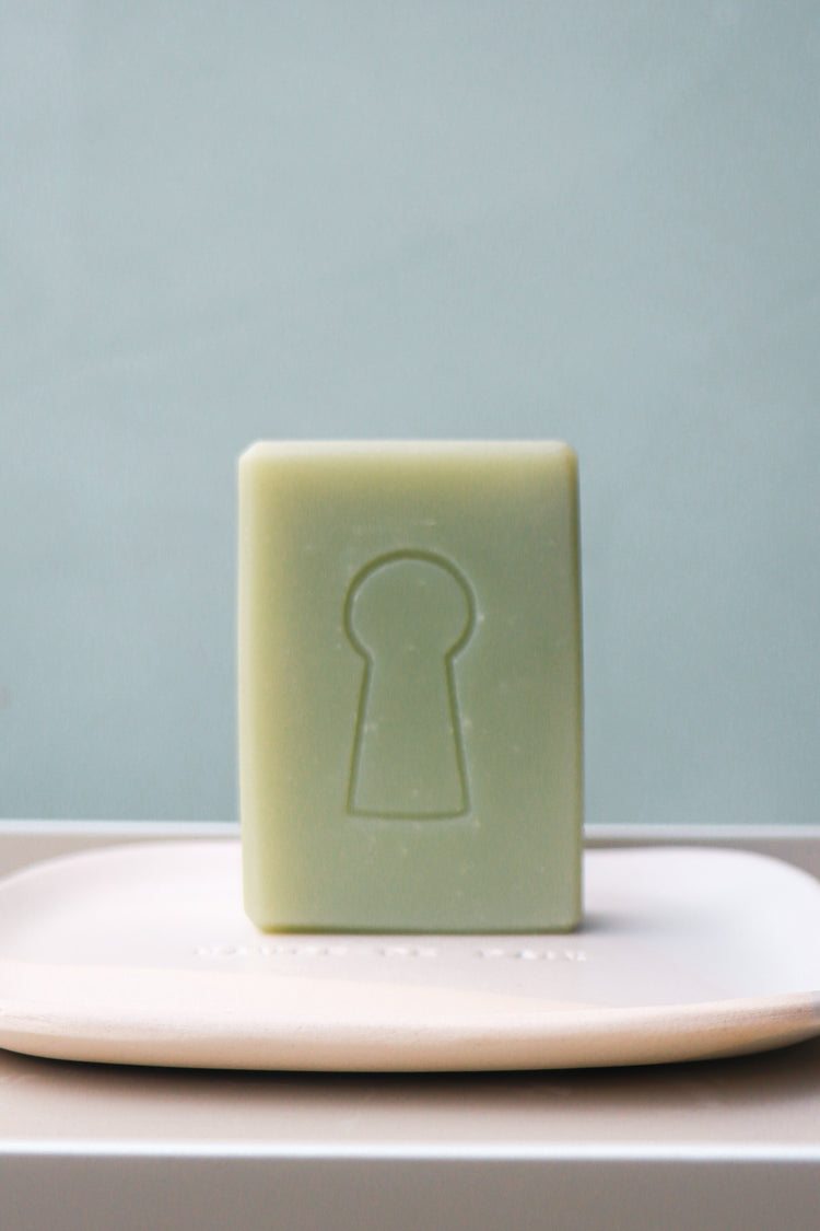 le Savon de  Belle Façon de Domaine Singulier, au parfum amande verte et fleurs de cerisier et le porte-savon en céramique

