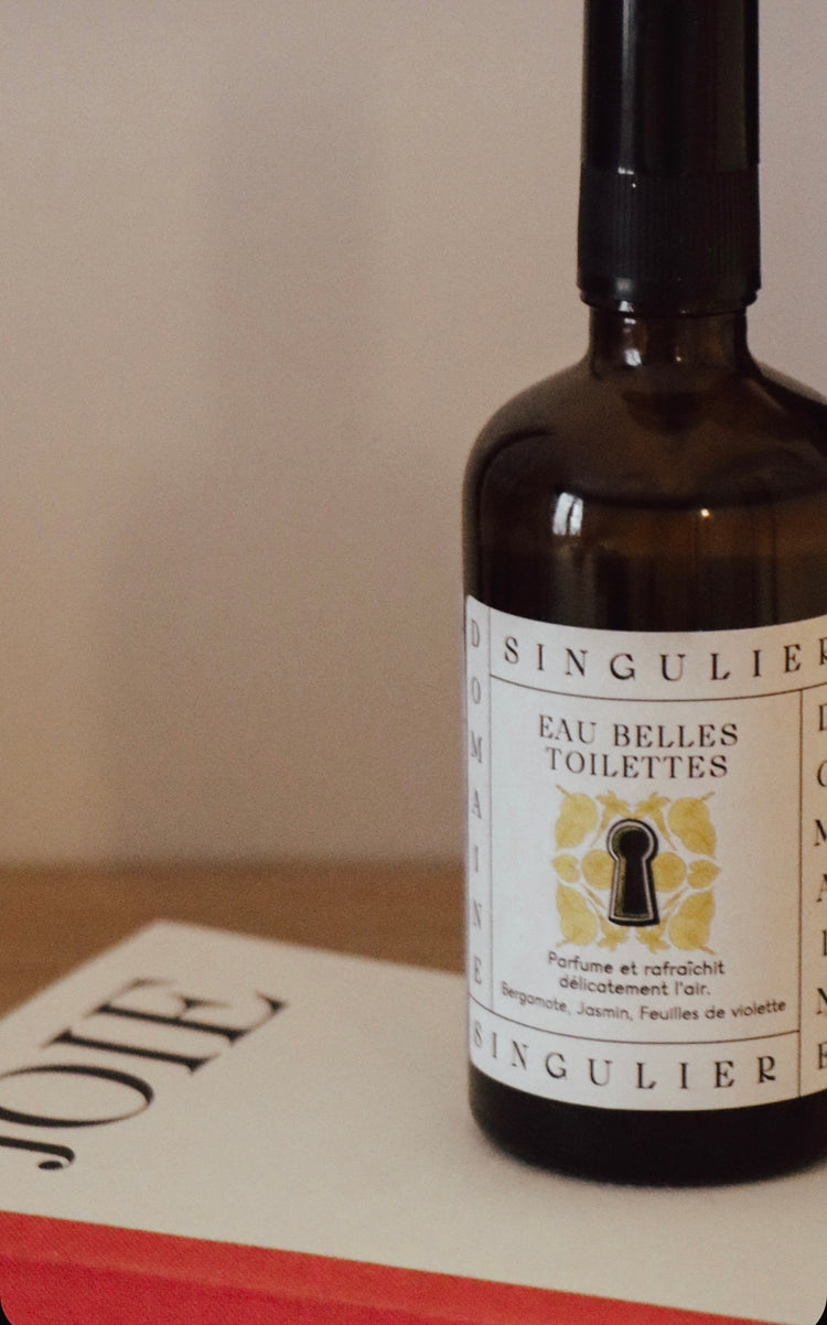 Eau Belles Toilettes de Domaine Singulier parfum bergamote en flacon 100 ml posé sur un livre portant le titre Joie, toute une invitation