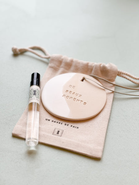 médaillon en céramique gravé du mantra de beaux moments avec le parfum nomade chic  de Domaine Singulier parfum bergamote et un pochon