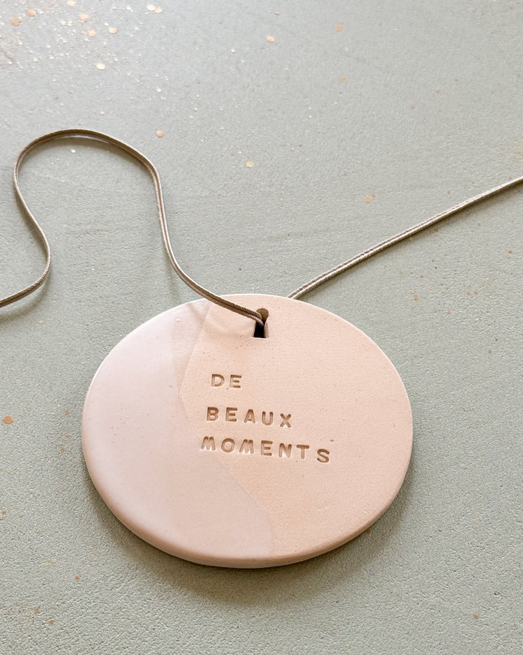 Le médaillon Domaine Singulier en céramique gravé du mantra de beaux moments , objet décoratif et à parfumer signé d'une artiste céramiste et fabriqué en France