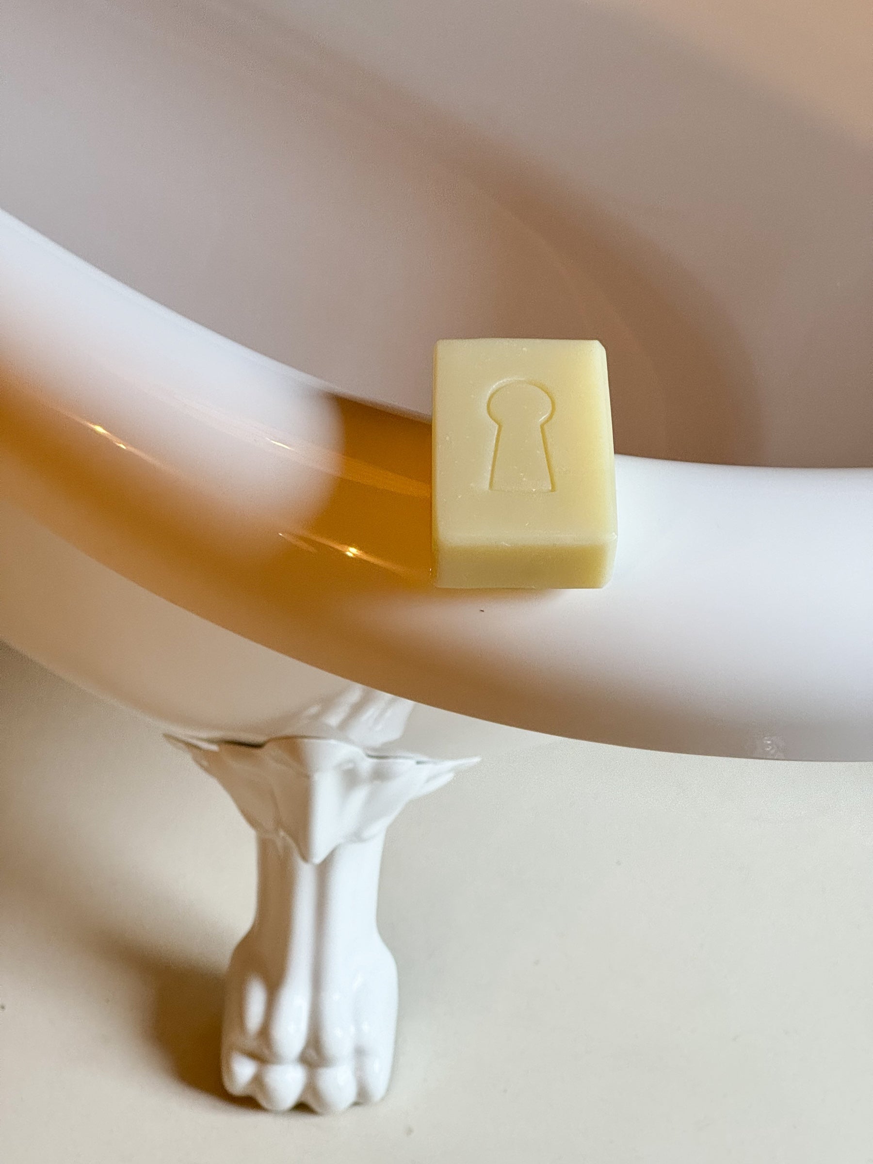 le Savon de Belle Façon Domaine Singulier aux senteurs de bergamote et 100% naturel posé sur une sublime baignoire 